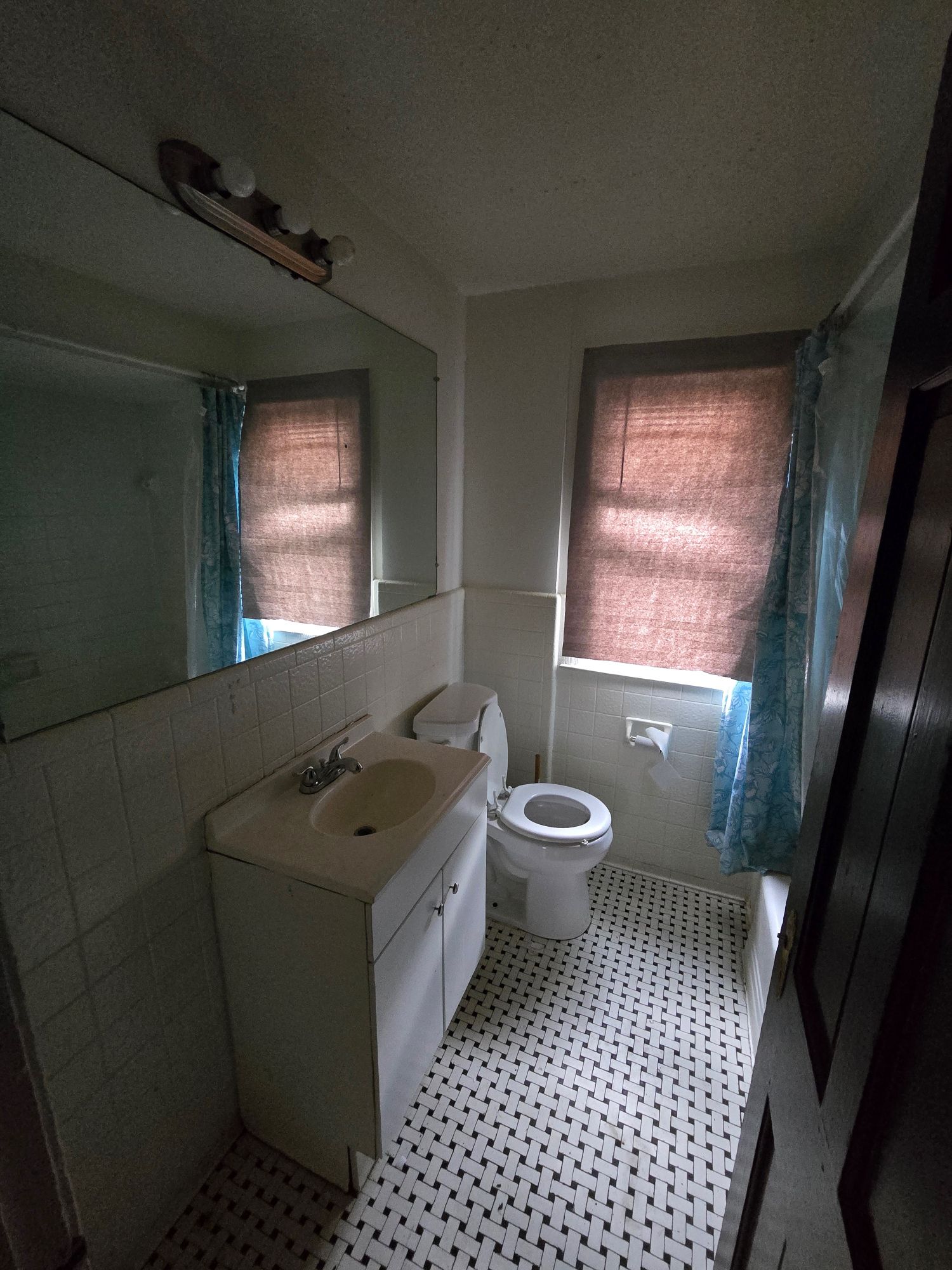 Bathroom before renovation with dated tile and fixtures